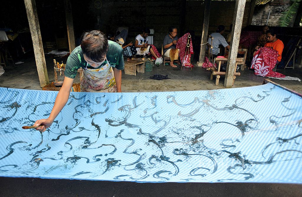 Pekerja memberi motif warna pada batik yang dibuat di industri batik motif geblek renteng Sembung Batik di Desa Gulurejo, Lendah, Kulonprogo, DI Yogyakarta, Jumat (10/1). 