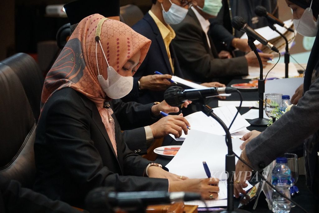 Ketua KPU Sumatera Barat Yanuk Sri Mulyani (kiri) menandatangani Surat Keputusan Penetapan Gubernur dan Wakil Gubernur Sumbar Terpilih di Padang, Sumbar, Jumat (19/2/2021). 