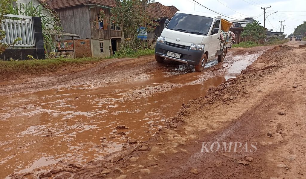 Sebuah kendaraan harus melewati titik jalan rusak di Kecamatan Tulung Selapan, Kabupaten Ogan Komering Ilir, Sumatera Selatan, Selasa (23/5/2023). Akibat kerusakan jalan, mobilitas warga di sekitar jalan itu terganggu. 