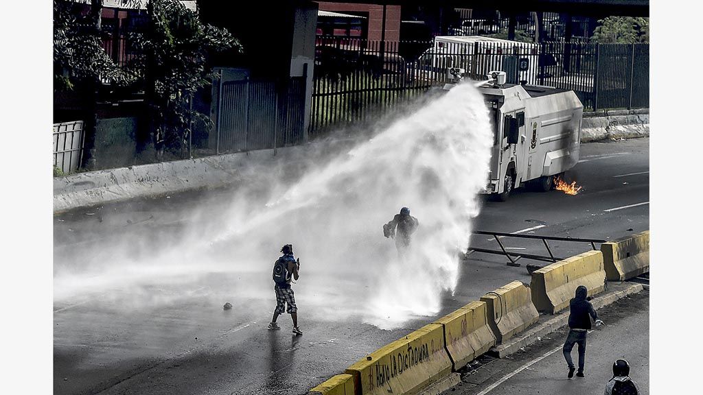 Polisi anti-huru-hara dari meriam air menyemprot demonstran penentang Presiden Venezuela Nicolas Maduro dalam unjuk rasa yang berlangsung Senin (1/5). Oposisi menentang keras langkah Maduro membentuk majelis konstituante untuk menyusun konstitusi baru.
