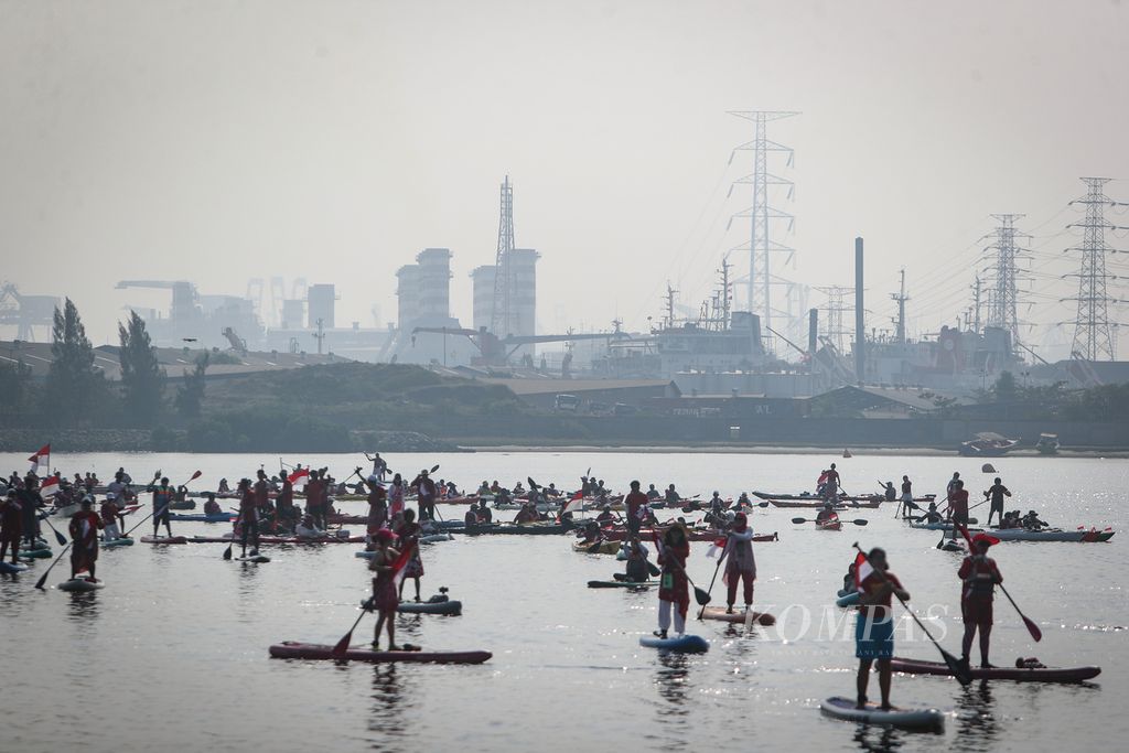 Para peserta mendayung kayak dan <i>stand up paddle </i>menuju lokasi pembentangan bendera Merah Putih di kawasan pesisir Ancol, Jakarta, Kamis (17/8/2023).