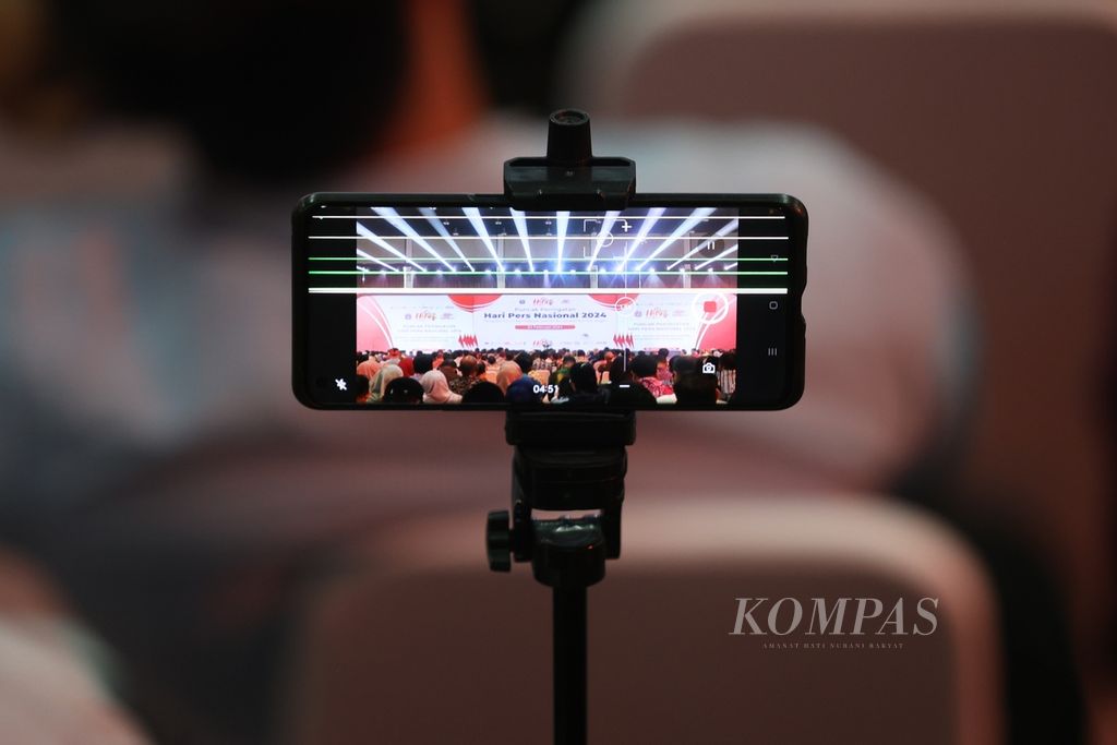 Ponsel wartawan merekam puncak peringatan Hari Pers Nasional 2024 di Ecovention Hall, Ancol, Jakarta, Selasa (20/2/2024). 