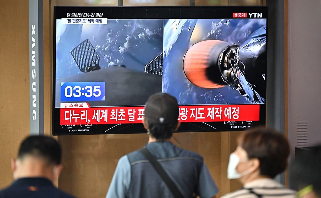Warga menonton layar televisi yang menampilkan siaran langsung peluncuran roket Falcon 9 yang membawa wahana pengorbit Bulan pertama milik Korea Selatan, Danuri, di sebuah stasiun kereta di Seoul, 5 Agustus 2022. 