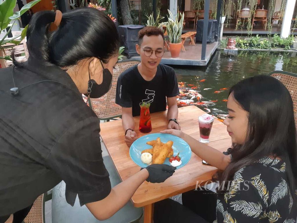 Pramusaji mengantarkan pesanan untuk konsumen Kedai Nyonya Rumah di Bandung, Jawa Barat, Jumat (20/5/2022).