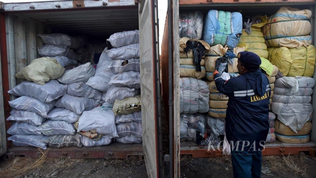 Anggota TNI AL mengecek balpres berisi pakaian bekas impor yang ada di dalam kontainer sitaan dari KM Mentari Crystal di Balai Prajurit Lantamal V, Surabaya, Jawa Timur, Rabu (8/8/2018). 