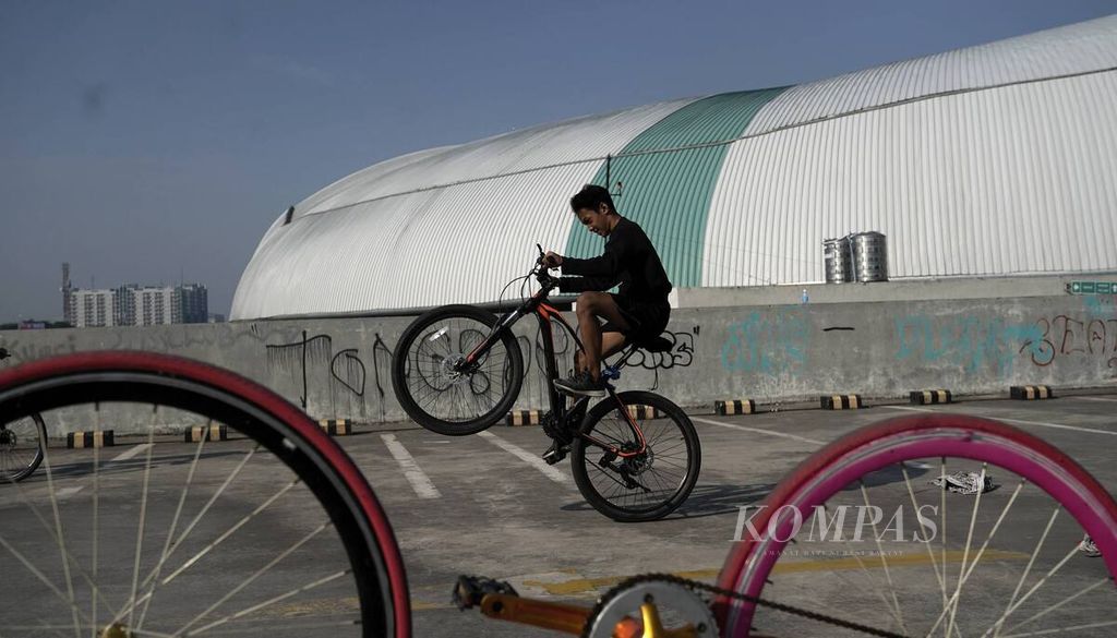 Remaja beraksi dengan sepedanya memanfaatkan hari bebas kendaraan bermotor (HBKB) di lahan parkir Stadion Patriot Candrabhaga, Kota Bekasi, Jawa Barat, Minggu (26/7/2020). 