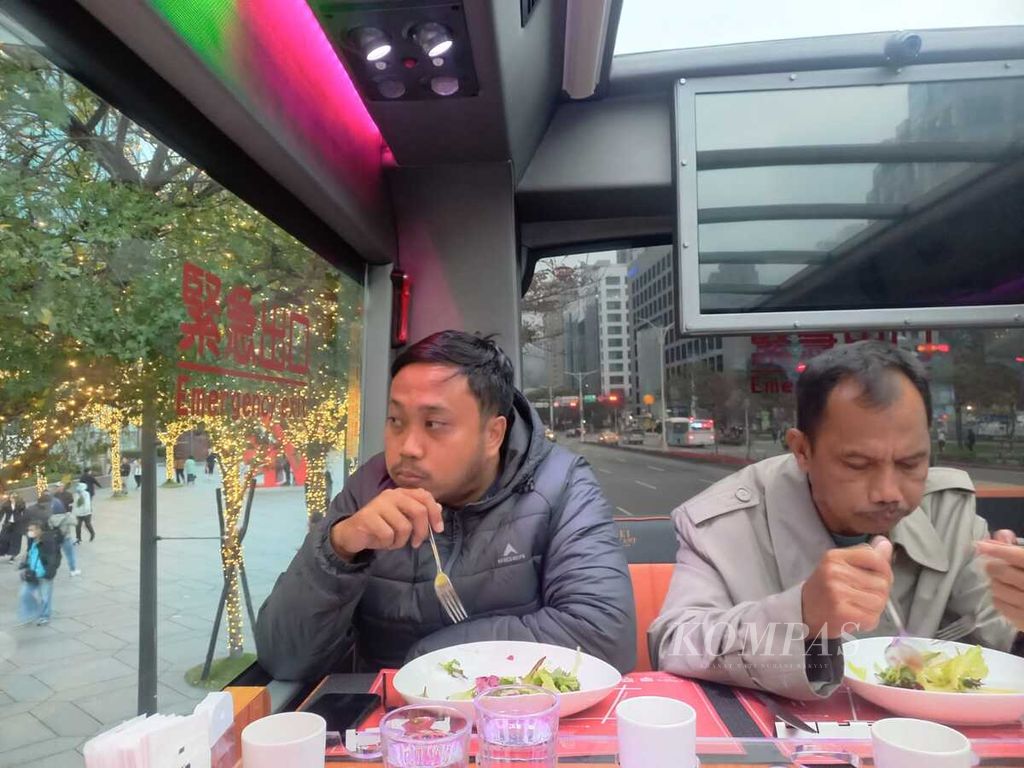 Jurnalis asal Indonesia menyantap hidangan di atas Taipei Restaurant Bus, Minggu (25/2/2024), di kota Taipei, Taiwan. 