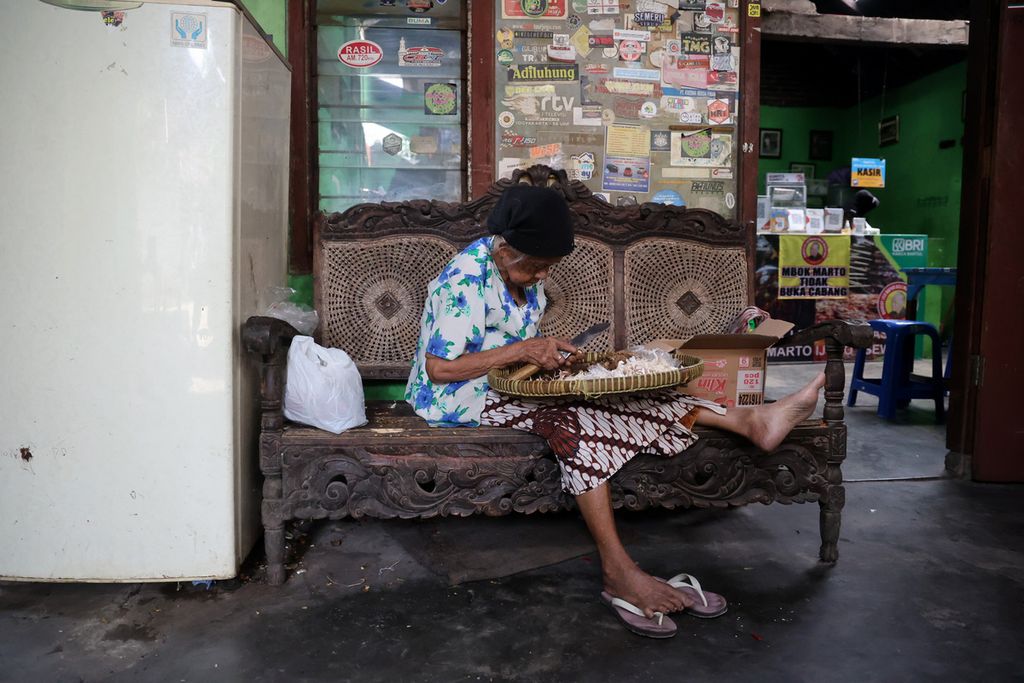 Mbah Marto (92) mengupas bahan bumbu masakan mangut lele di rumah makan Mangut Lele Dapur Asli Mbok Marto Ijoyo di Kecamatan Sewon, Kabupaten Bantul, Daerah Istimewa Yogyakarta, Rabu (21/9/2022). 