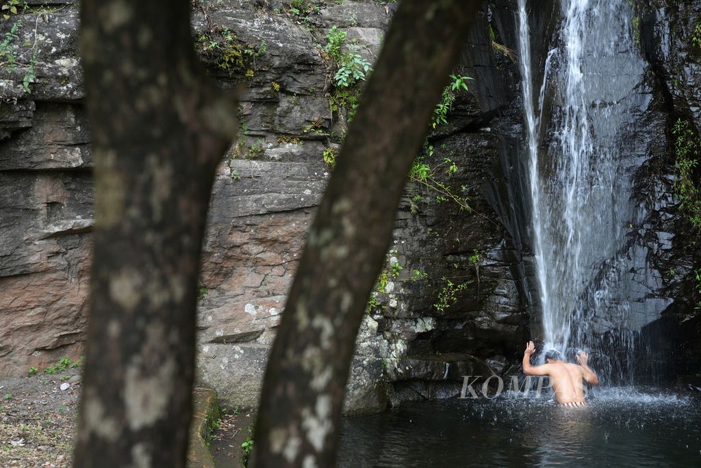 Wisatawan menikmati segarnya air terjun Curug Gongseng di Desa Cibuntu, Kecamatan Pasawahan, Kabupaten Kuningan, Jawa Barat, Kamis (2/5/2024). Air terjun setinggi 15 meter ini menjadi salah satu tujuan wisatawan untuk mandi dan merasakan segarnya kucuran air pegunungan yang bening.