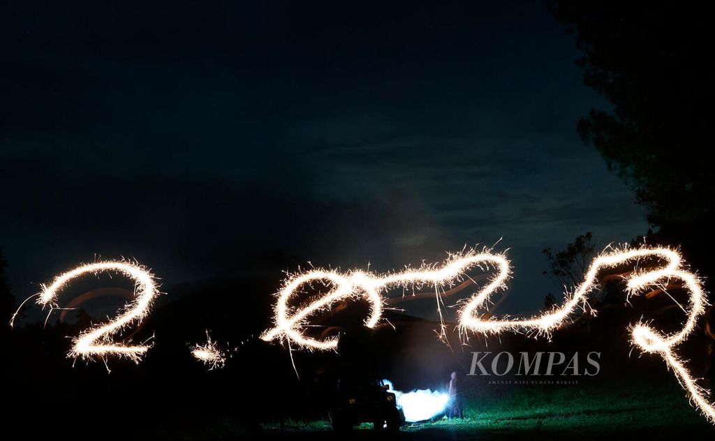 Pengunjung menyalakan kembang api dengan membuat angka tahun 2023 saat mereka berwisata dan berkemah di Jurang Jero, Kabupaten Magelang, Jawa Tengah, Minggu (1/1/2023). 
