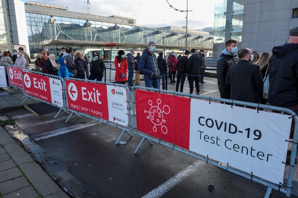 Orang-orang mengantri di luar pusat tes Covid-19 yang didirikan di Bandara Brussel di Zaventem, Belgia (20/12/2020). Munculnya varian Omicron membuat negara-negara di dunia memperketat pengetesan, pelacakan kasus, serta meningkatkan vaksinasi Covid-19. 
