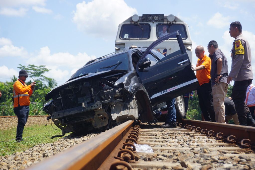 Sebuah lokomotif dikerahkan untuk menarik mobil yang terjepit di jembatan kereta api di Sumpiuh, Banyumas, Jawa Tengah, Rabu (19/4/2023).