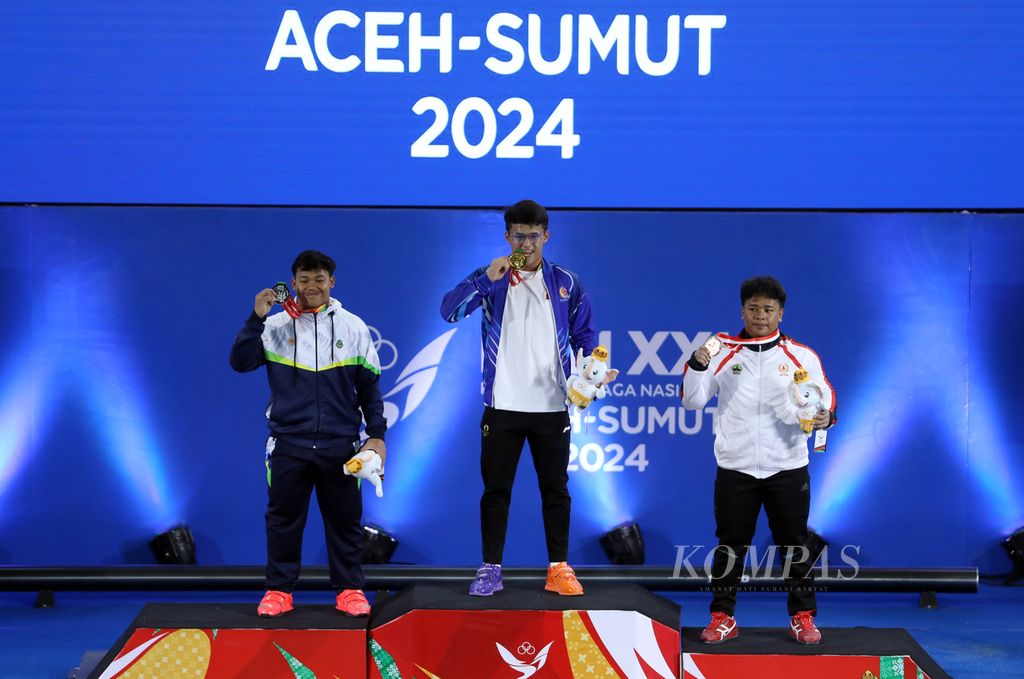 Lifter Banten, Rizki Juniansyah, meraih emas cabang angkat besi kelas 89 kg PON Aceh-Sumut 2024 di Banda Aceh, Sabtu (7/9/2024). Rizki juga sukses memecahkan tiga rekor nasional, yakni angkatan <i>snatch </i>dengan 160 kg, angkatan <i>clean and jerk </i>dengan 200 kg, dan total angkatan dengan 360 kg.