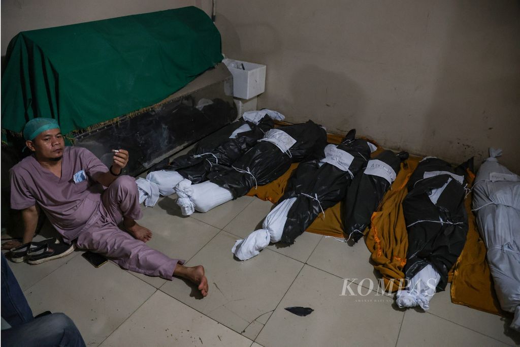 Petugas rumah sakit beristirahat setelah mengidentifikasi korban meninggal akibat kecelakaan bus tunggal di RSU Radjak Purwakarta, Provinsi Jawa Barat, Jumat (15/12/2023). 