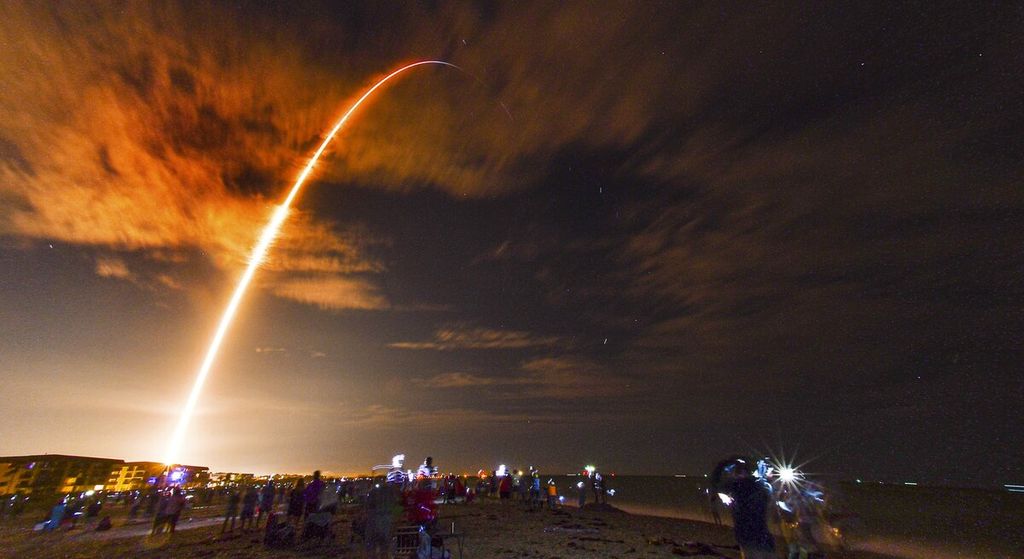 Warga di pantai di Cape Canaveral, Florida, menyaksikan peluncuran SpaceX Falcon 9 Crew Dragon dalam misi Crew-1 yang membawa empat astronaut dari landasan peluncuran 39-A, Pusat Antariksa Kennedy, Florida, AS, Minggu (15/11/2020).  
