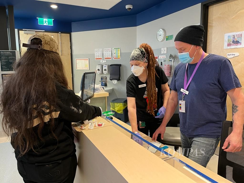 Sejumlah staf sedang melayani seorang pengunjung di ruang penyuntikan di bawah supervisi medis, di Pusat Kesehatan Komunitas North Richmond, Melbourne, Australia, Senin (17/4/2023).