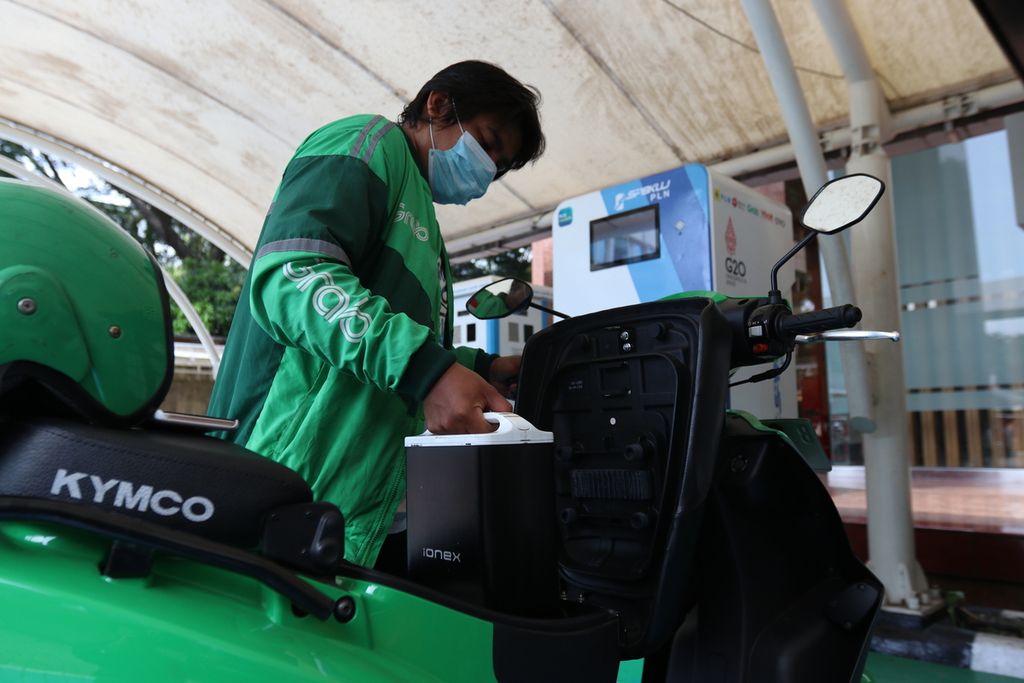 An online motorcycle taxi driver removes a battery from an electric motor at the PLN Distribution Public Electric Vehicle Charging Station (SPLKU) for Greater Jakarta Distribution, Gambir, Central Jakarta, Thursday (6/10/2022).