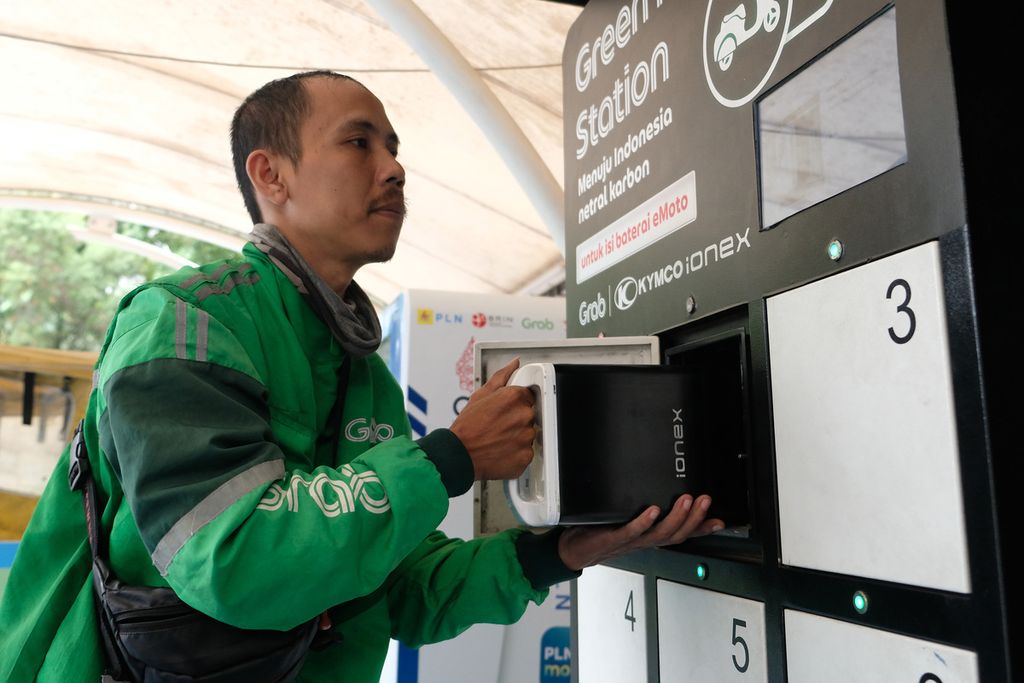 Pengemudi ojek daring mengambil baterai sepeda motor listrik di stasiun pengisian kendaraan listrik umum di Kantor PT Perusahaan Listrik Negara (Persero), Gambir, Jakarta Pusat, Selasa (6/12/2022). 