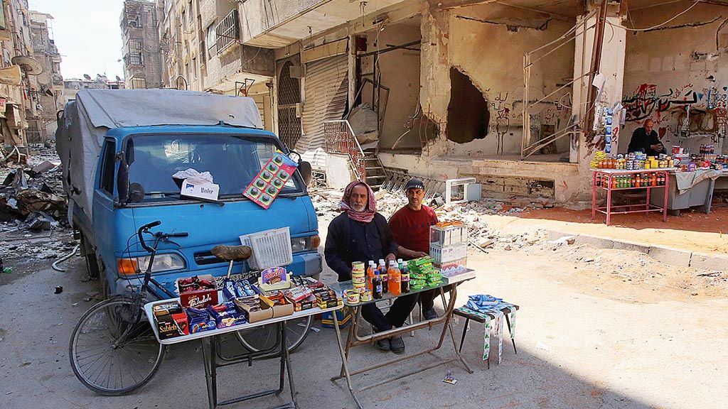 Warga berjualan berbagai barang di jalan, di kota Zamalka, yang sebelumnya dikuasai pemberontak, di Ghouta timur, Suriah, Rabu (11/4/2018).  Pemerintah Suriah kini menguasai hampir seluruh Ghouta timur setelah berminggu-minggu menyerang kelompok pemberontak yang menguasai wilayah itu.  