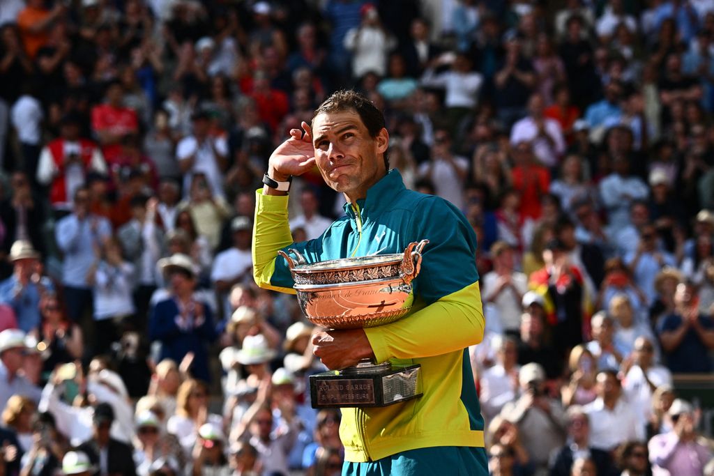 Petenis Spanyol Rafael Nadal menggenggam trofi juara pada Perancis Terbuka usai mengalahkan petenis Norwegia Casper Ruud pada laga final di Lapangan Philippe Chatrier, Roland Garros, Paris, Minggu (5/6/2022). Nadal menang dengan skor 6-3, 6-3, 6-0.