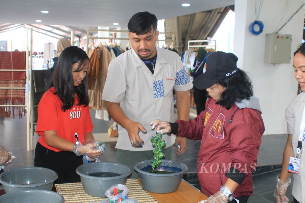Pengunjung mencoba mewarnai kain dengan bahan alami dari tumbuh-tumbuhan di stan Jabu Bonang di Kabupaten Toba, Sumatera Utara, Sabtu (2/3/2024). 