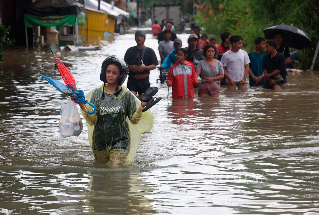 Warga berjalan keluar dari permukiman untuk mencari lokasi aman dari genangan banjir di Kampung Sawah Besar, Kota Semarang, Jawa Tengah, Kamis (14/3/2024). Cuaca buruk dalam beberapa hari ini menyebabkan banjir hingga melumpuhkan fasilitas publik dan menggenangi permukiman warga. 