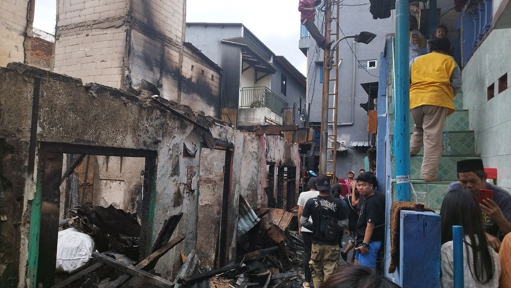 Sejumlah warga RT 005 Kelurahan Kalianyar, Kecamatan Tambora, Jakarta Barat, tengah membersihkan rumahnya dari puing-puing sisa kebakaran, Sabtu (31/12/2022).