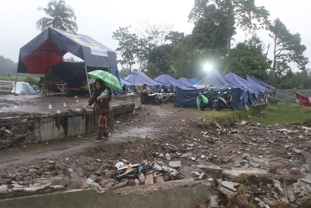 Seorang warga berjalan keluar dari tenda pengungsian di Desa Cibulakan, Kecamatan Cugenang, Kabupaten Cianjur, Jawa Barat, Jumat (16/12/2022). Ratusan orang mengungsi di tenda-tenda tersebut setelah rumah mereka ambruk dilanda gempa, Senin (21/11/2022) 