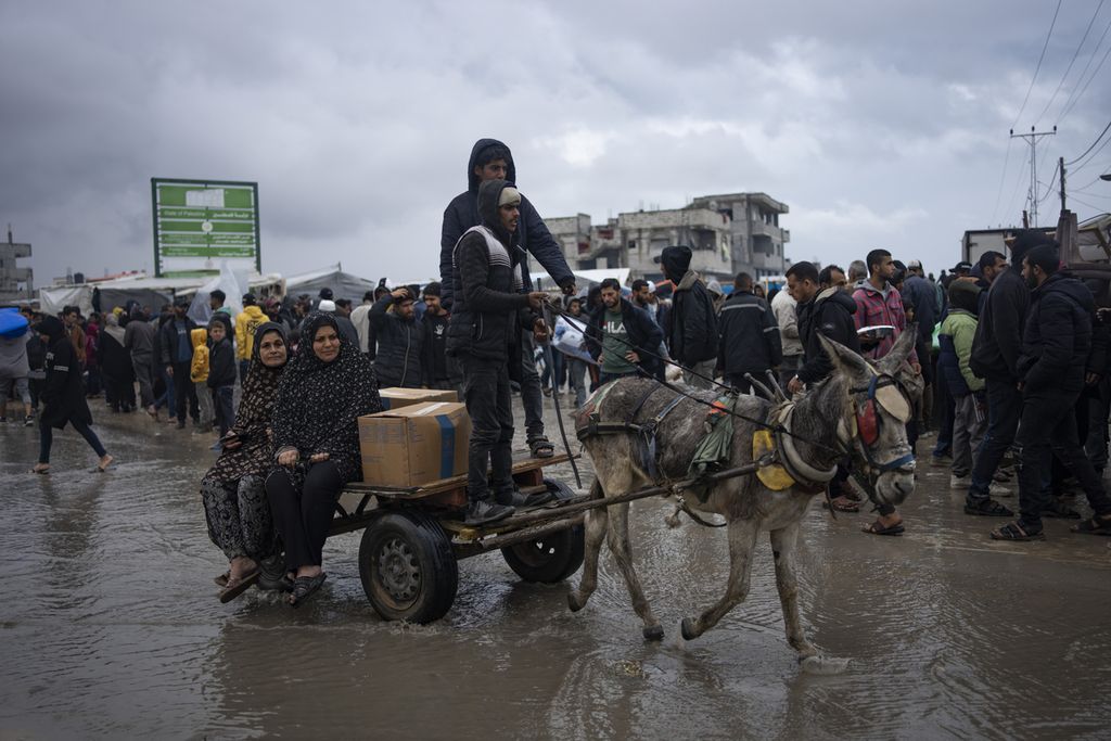 Para pengungsi Palestina berjalan menuju Rafah, Sabtu (27/1/2024), menggunakan alat transportasi yang ada untuk menghindari serangan militer Israel di lokasi pengungsian mereka. 