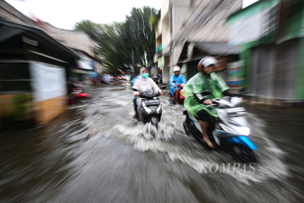 Kendaraan bermotor menerjang banjir yang merendam jalan di Kelurahan Kapuk, Kecamatan Cengkareng, Jakarta Barat, Jumat (22/3/2024). Banjir akibat curah hujan yang tinggi ini menyebabkan sejumlah ruas jalan terendam banjir dan tak dapat dilalui.