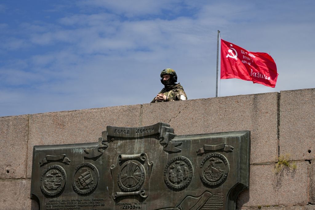Seorang tentara Rusia berjaga-jaga di Monumen Pahlawan di kota Kherson, Ukraina, Jumat (20/5/2022). Kherson jatuh ke tangan Rusia pada 3 Maret 2022.