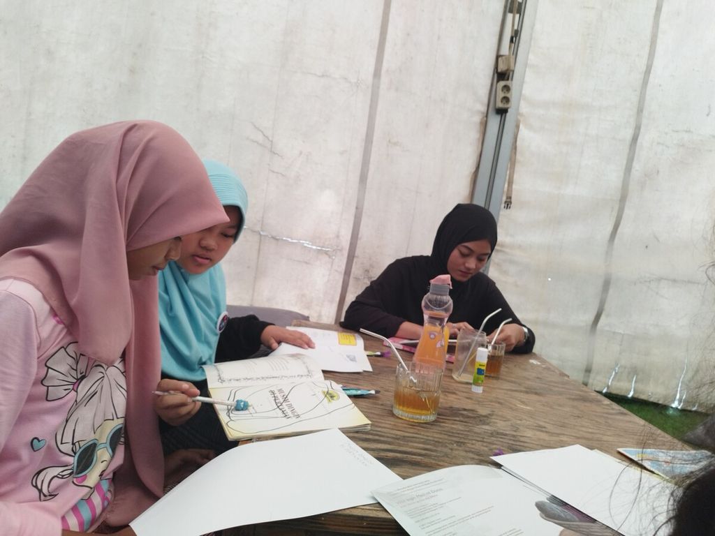 Anak-anak tengah menuliskan kembali cerita yang mereka baca dalam kegiatan membaca dan menulis bersama di kawasan Cibubur, Kecamatan Ciracas, Jakarta Timur, Minggu (29/1/2023).