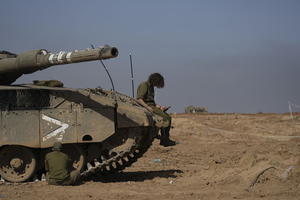 Tentara Israel duduk di atas dan samping tank di dekat perbatasan Jalur Gaza  pada  hari pertama jeda kamanusiaan, Jumat (24/11/2023). 