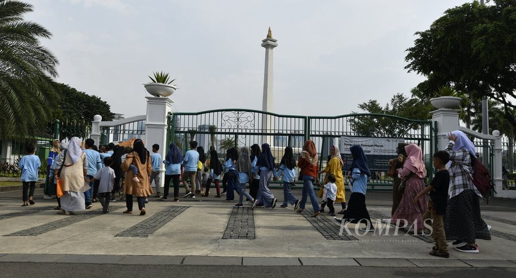 Rombongan pelajar memasuki kawasan Monumen Nasional (Monas), Jakarta, melalui pintu gerbang Silang Monas Timur Laut, Minggu (26/6/2022).  Jumlah pengunjung diperkirakan akan terus meningkat karena saat ini bersamaan dengan masa libur panjang kenaikan sekolah. 