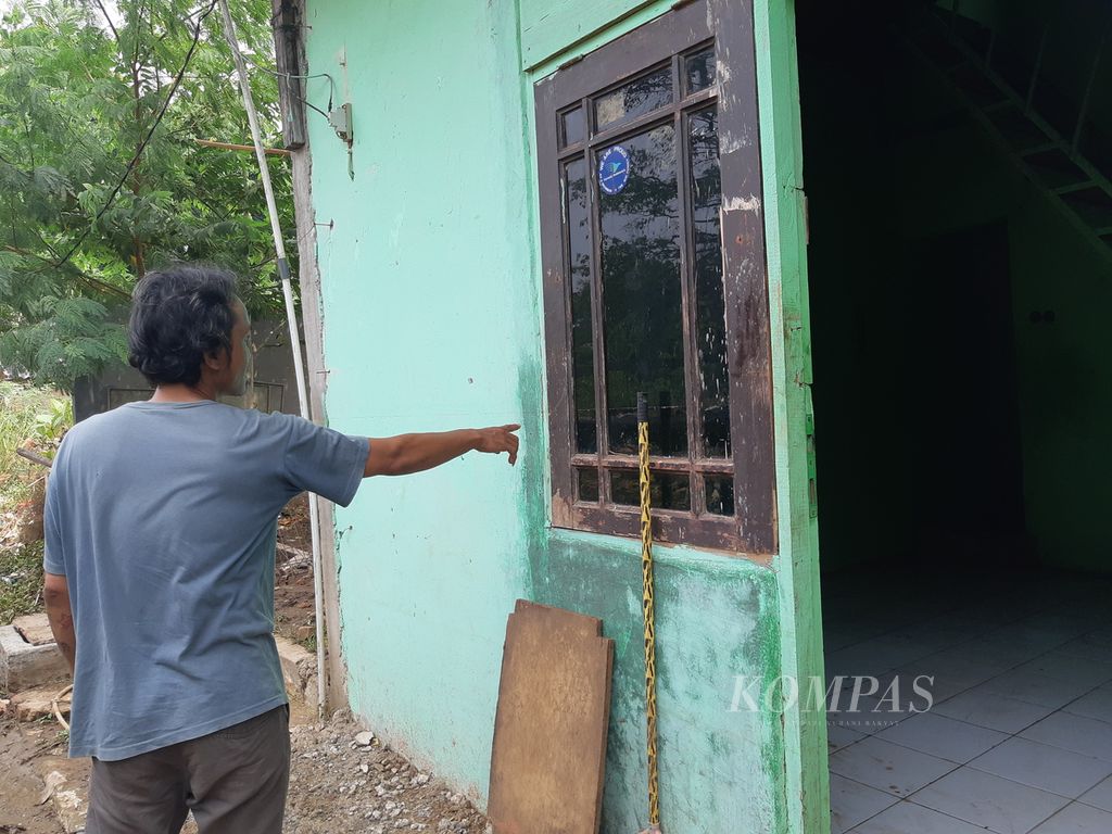 Ferdi (40) menunjukkan bekas banjir di salah satu rumah di Kelurahan Rawajati, Kecamatan Pancoran, Jakarta Selatan, Rabu (8/11/2023).