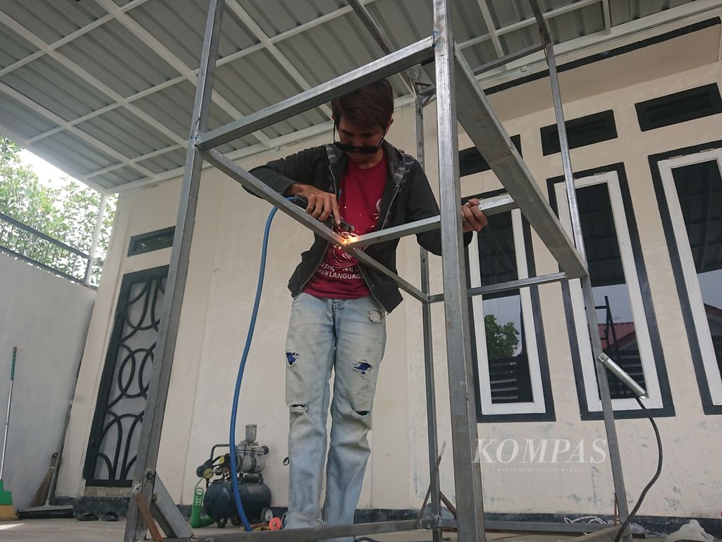 Rizky Adly (27), seorang teman tuli, sedang mengelas di bengkelnya di Desa Kaju, Kecamatan Baitussalam, Kabupaten Aceh Besar, Aceh, Rabu (12/10/2022). Para teman tuli banyak bekerja di sektor informal, mereka butuh pendampingan untuk bisa berkembang.