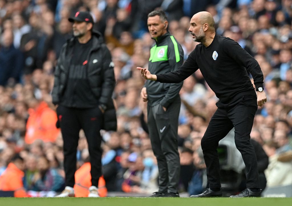 Manajer Manchester City Pep Guardiola (kanan) dan Manajer Liverpool Juergen Klopp (kiri) menyaksikan dengan saksama jalannya laga dari pinggir lapangan dalam lanjutan Liga Inggris pekan ke-31 di Stadion Etihad, Manchester, Inggris, Senin (11/4/2022) dini hari WIB. Baik Guardiola maupun Klopp sama-sama menurunkan formasi terbaiknya dalam laga ini, yang menghasilkan salah satu laga paling menarik Liga Inggris musim ini.