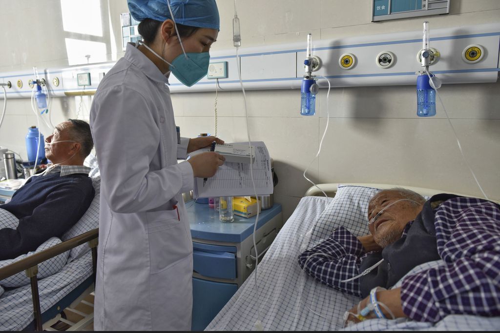 Seorang perawat sedang berbicara dengan pasien lansia mengenai obat Covid-19 di sebuah rumah sakit di Fuyang, Provinsi Anhui, China, 4 Januari lalu. 