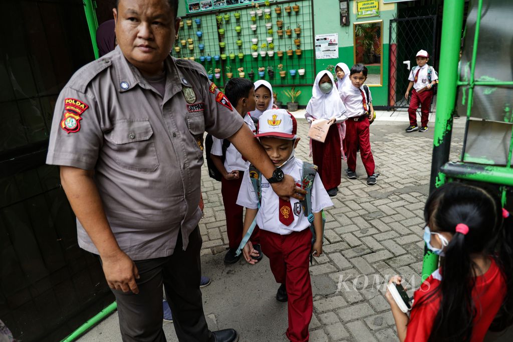 Satpam sekolah memastikan para siswa dijemput oleh orangtua ataupun keluarga siswa saat pulang sekolah di SD Negeri Joglo 05, Kembangan, Jakarta Barat, Senin (30/1/2023). 