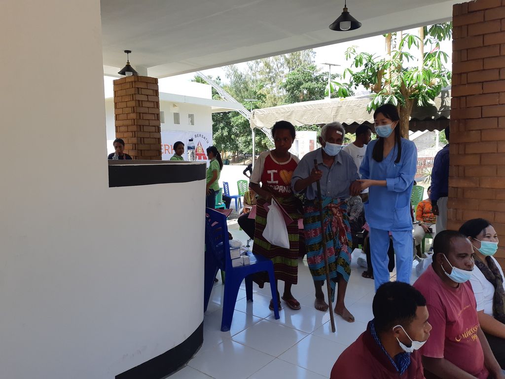 Petugas menuntun pasien masuk ke ruang operasi katarak di Wini, Kabupaten Timor Tengah Utara, Nusa Tenggara Timur, pada Jumat (16/9/2022). Masuk mengunakan tongkat, setelah operasi pasien keluar tanpa bantuan tongkat.
