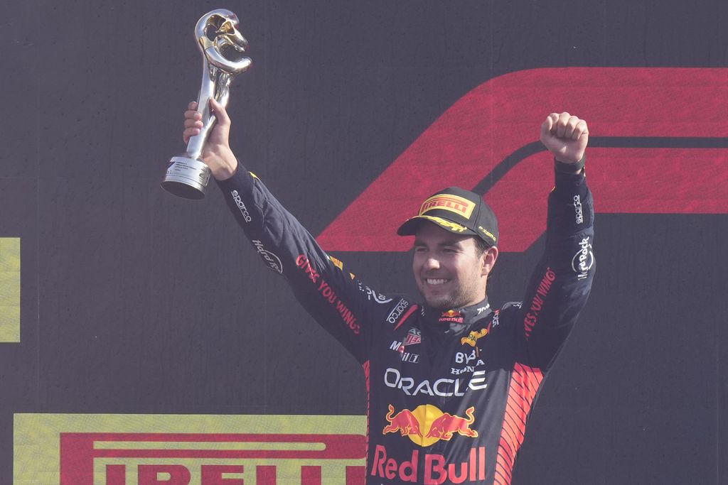 Pebalap Red Bull, Sergio Perez, melakukan selebrasi di podium kedua setelah balapan Grand Prix Formula 1 seri Italia di Sirkuit Monza, Monza, Italia, Minggu (3/9/2023). Rekan setim Perez, Max Verstappen, menjadi pemenang Grand Prix seri Italia, yang sekaligus merupakan kemenangan ke-10 beruntun. 