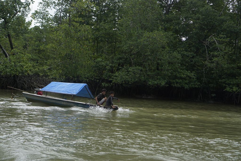 Perahu nelayan melintas di antara hutan mangrove di Teluk Balikpapan, Kalimantan Timur, Minggu (11/9/2022).
