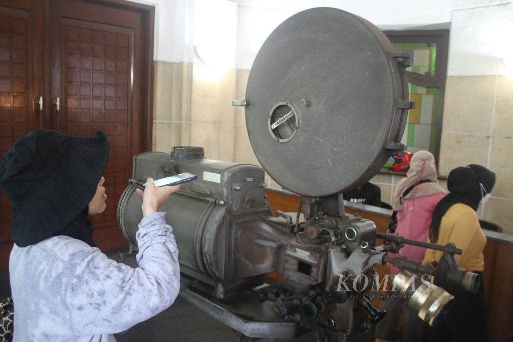 Seorang peserta Bioscoop Bandoeng mengamati proyektor film lama yang dipajang di Bioskop De Majestic, Minggu (3/4/2022). Kegiatan ini diikuti belasan peserta dan menceritakan perjalanan bioskop di Kota Bandung.