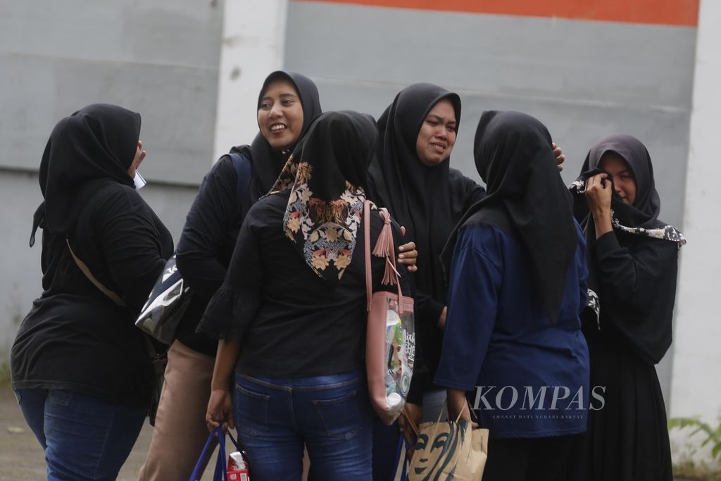 Several employees of the PT Dean Shoes Karawang shoe factory, West Java, hugged each other after receiving a letter of termination of employment, Tuesday (28/3/2023). PT Dean Shoes in Karawang Regency closed the factory and stopped its operations in April 2023 and 3,329 workers were laid off.