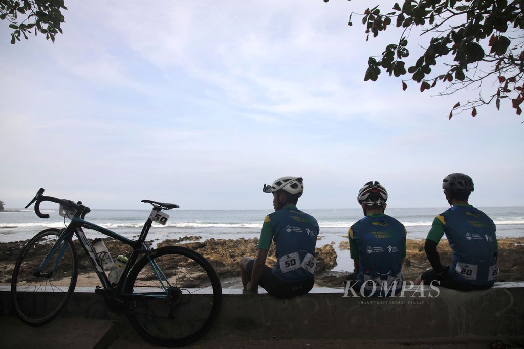 Peserta balap sepeda Cycling de Jabar 2022 menikmati pemandangan pantai di Rancabuaya, Garut, Jawa Barat, sebelum memulai perlombaan etape kedua, Minggu (28/8/2022). 