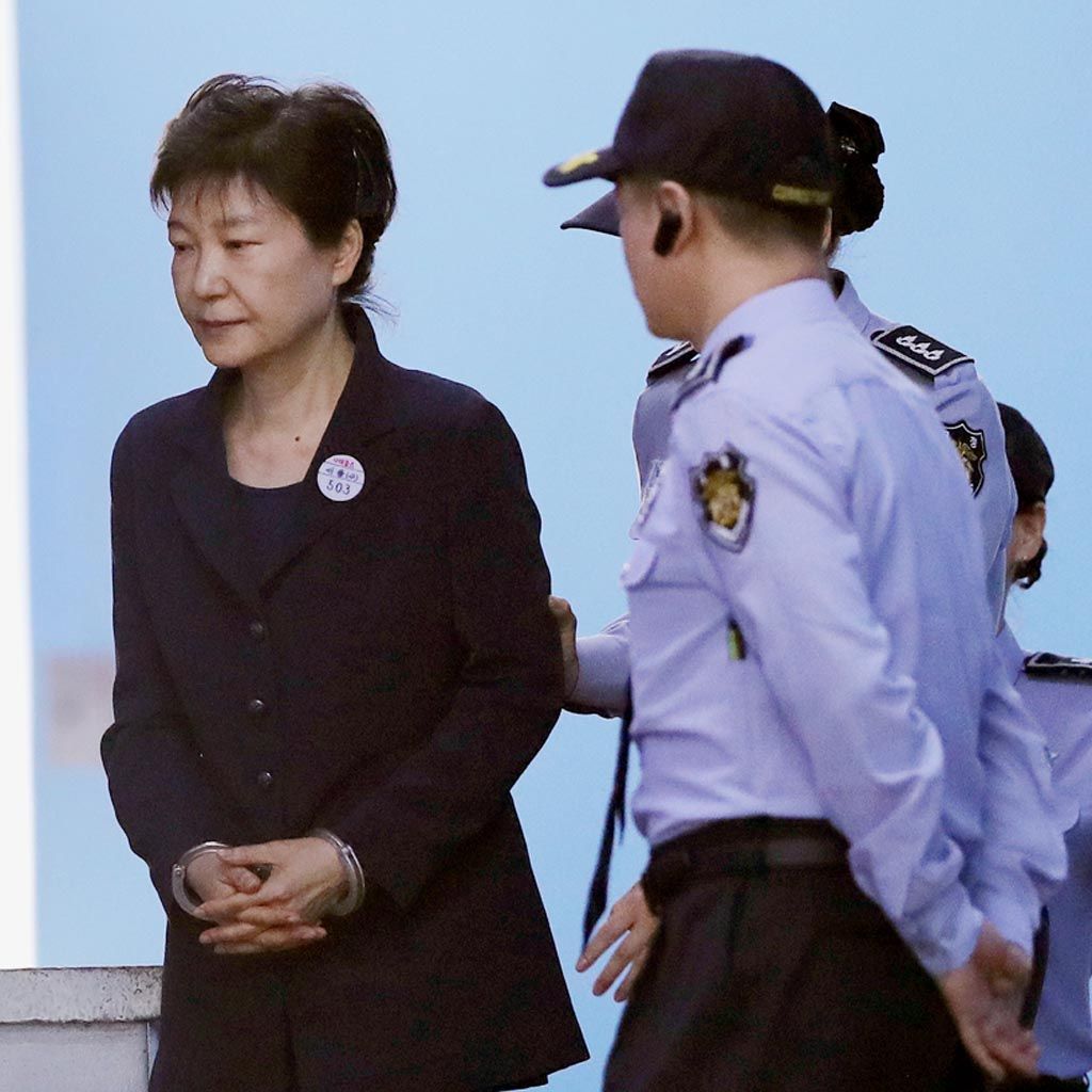 Mantan Presiden Korea Selatan  Park Geun-hye dengan tangan terborgol meninggalkan ruang sidang Pengadilan Distrik Pusat Seoul, Korsel, Selasa (23/5). Ini adalah kemunculan pertama Park di depan publik setelah dimakzulkan dari kursi presiden dan ditahan pada 31 Maret.