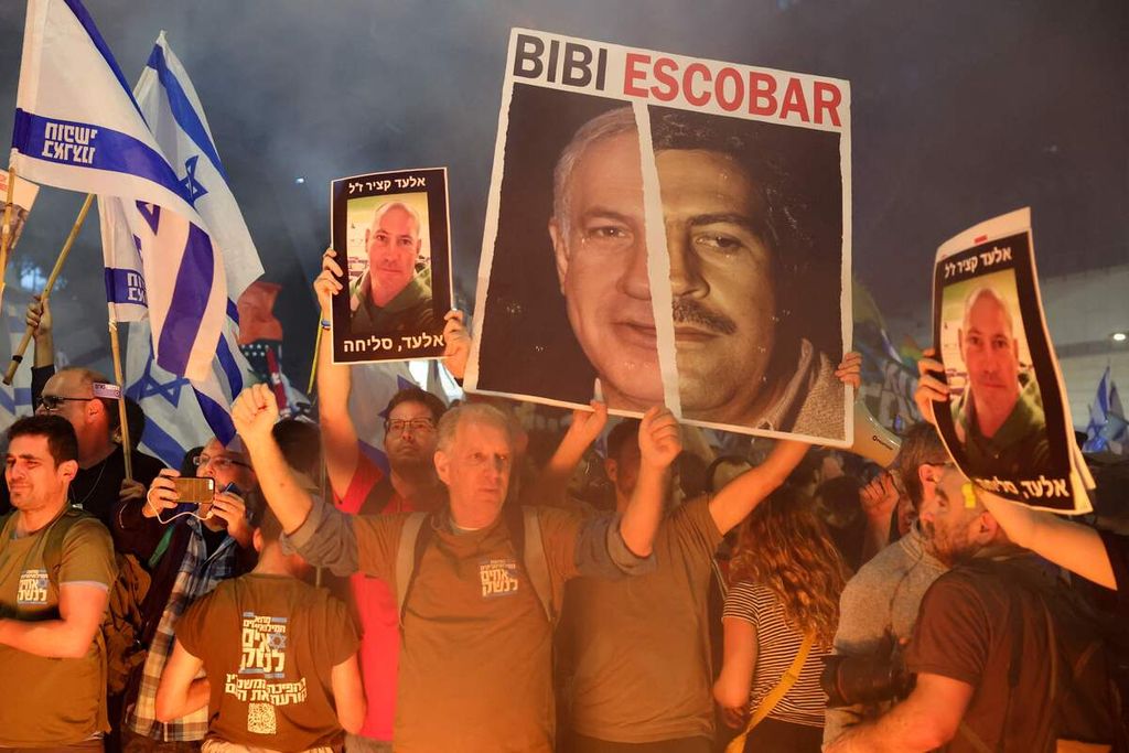 Para anggota keluarga dan kerabat sandera warga Israel membawa poster bergambar Elad Katzir (poster kiri dan kanan), salah satu sandera), dalam unjuk rasa di depan kantor Kementerian Pertahanan Israel di Tel Aviv, Israel, Sabtu (6/4/2024). 