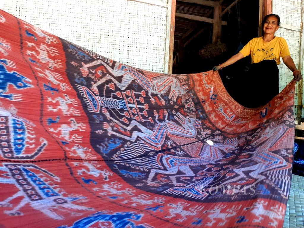 Seorang perempuan perajin tenun Sumba menunjukkan salah satu karya tenun tua warisan orangtuanya seharga Rp 25 juta, Rabu (1/5/2019), di Sumba Timur, Nusa Tenggara Timur. Perempuan memiliki peran sentral dalam keluarga di Sumba, salah satunya membuat tenun-tenun khas Sumba yang turut menjadi salah satu bagian penting dalam pemberian belis atau mas kawin