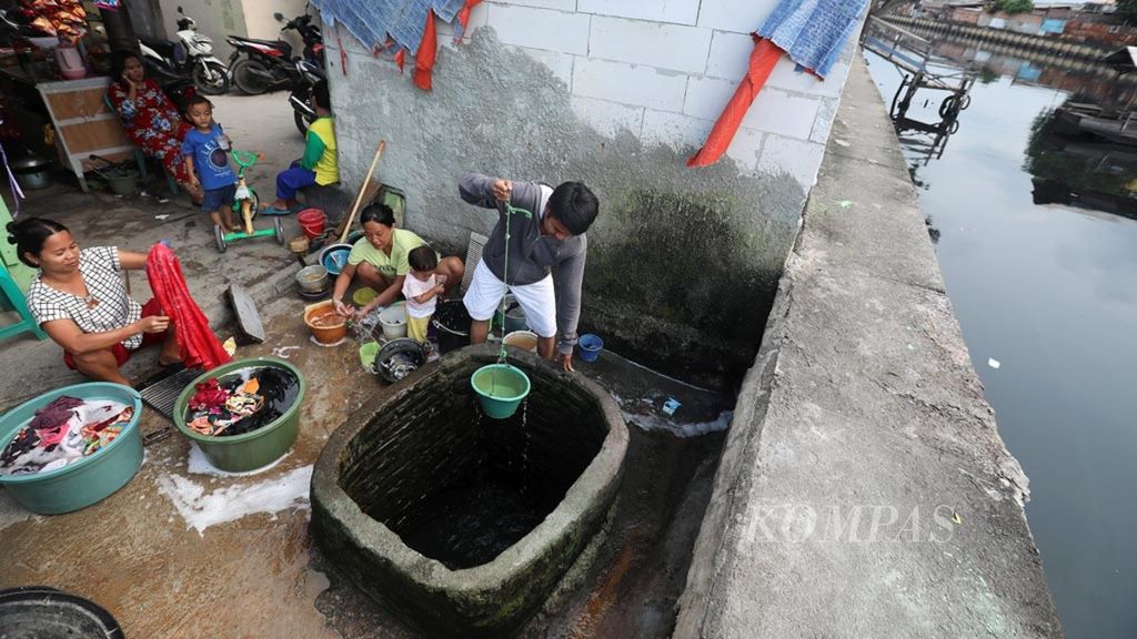 Warga di Kampung Gusti, Penjaringan, Jakarta Utara, menggunakan air sumur dari rembesan Kali Angke untuk mandi dan mencuci, Selasa (12/2/2019). 