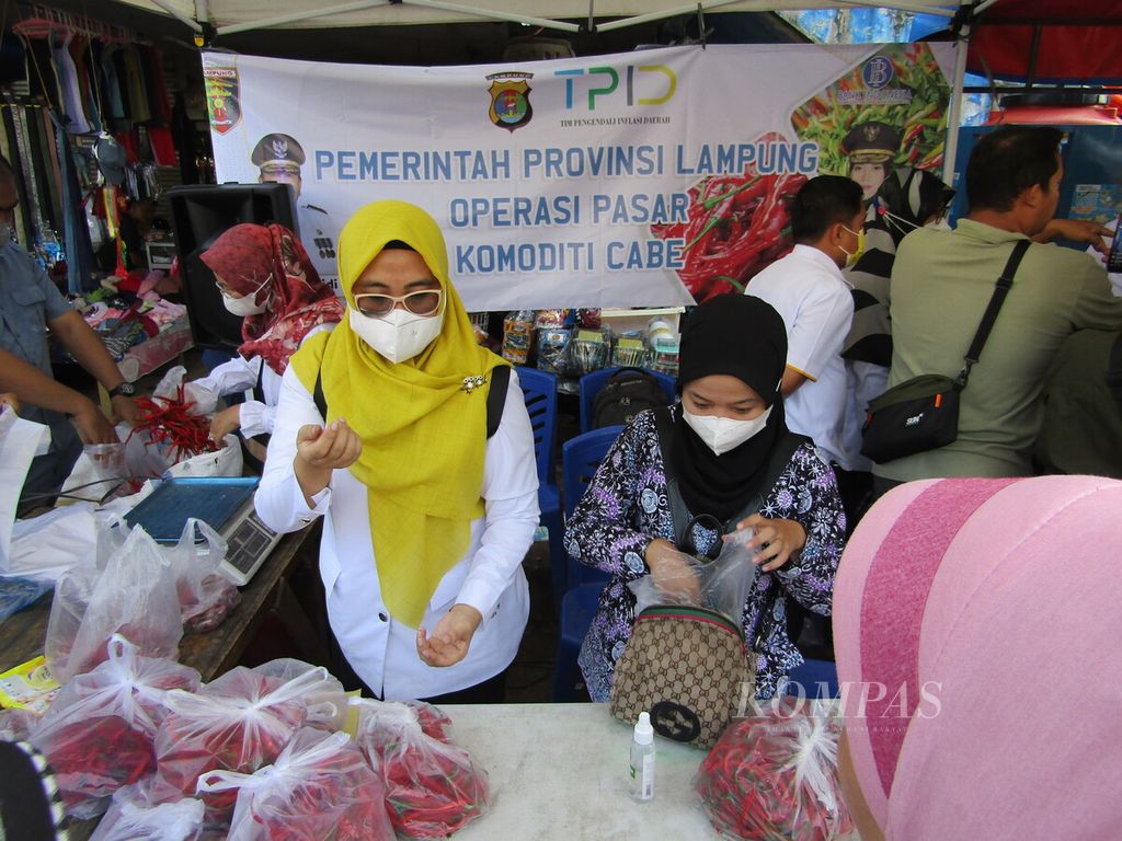 Petugas melayani pembeli cabai dan bawang merah dalam kegiatan operasi pasar yang digelar Pemerintah Provinsi Lampung, Rabu (22/6/2022), di Pasar Tugu, Bandar Lampung. Kegiatan itu dilakukan untuk mengendalikan harga pangan.